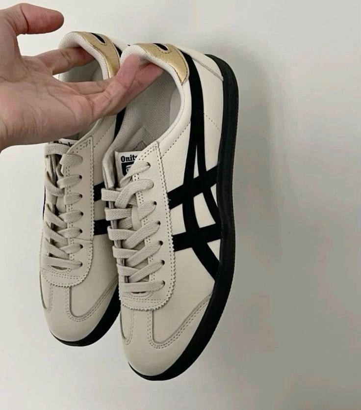 Une paire de baskets tenue dans une main